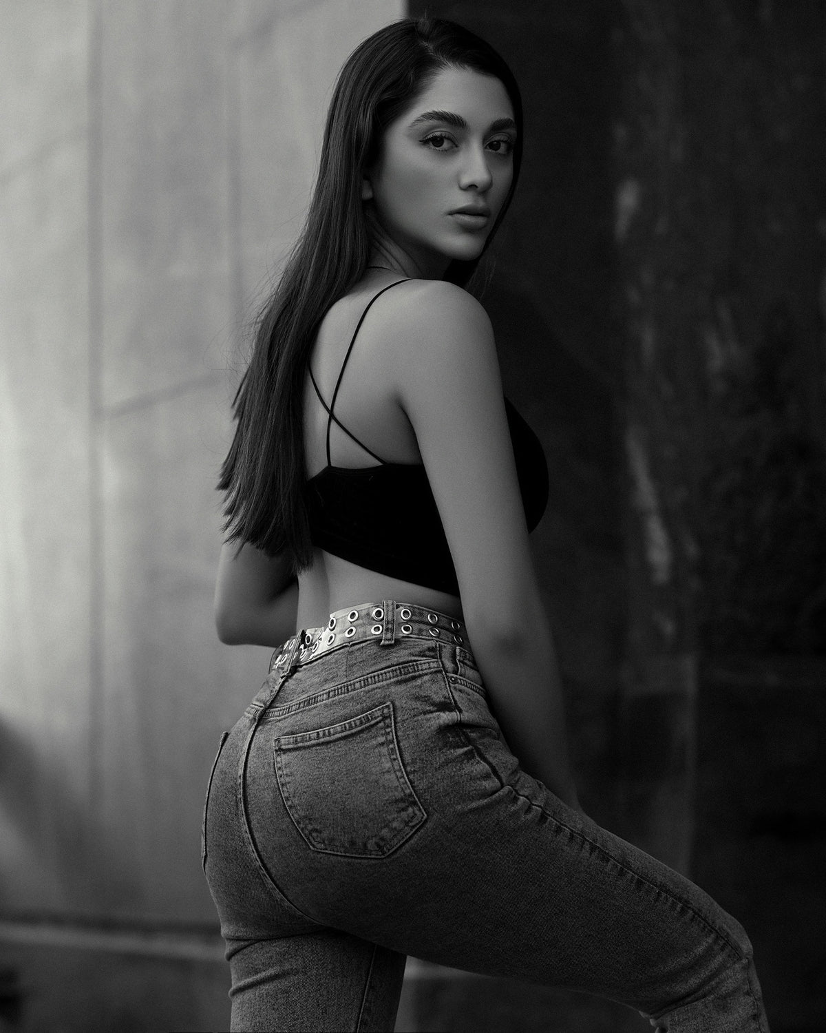 XAYWEAR black crop top with thin straps paired with high-waisted jeans on a female model