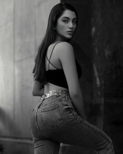 XAYWEAR black crop top with thin straps paired with high-waisted jeans on a female model