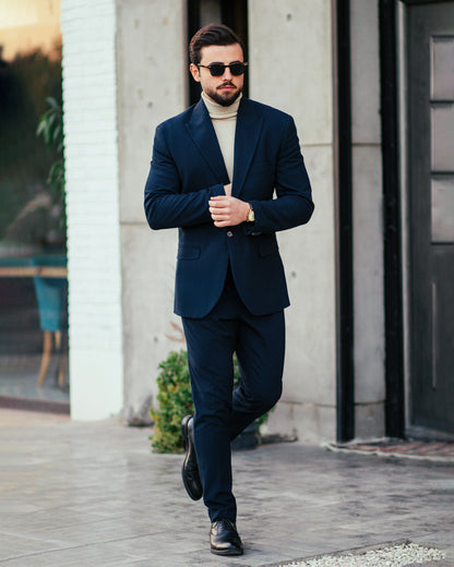Stylish man wearing XAYWEAR men blue suit with black shoes and sunglasses walking outdoors