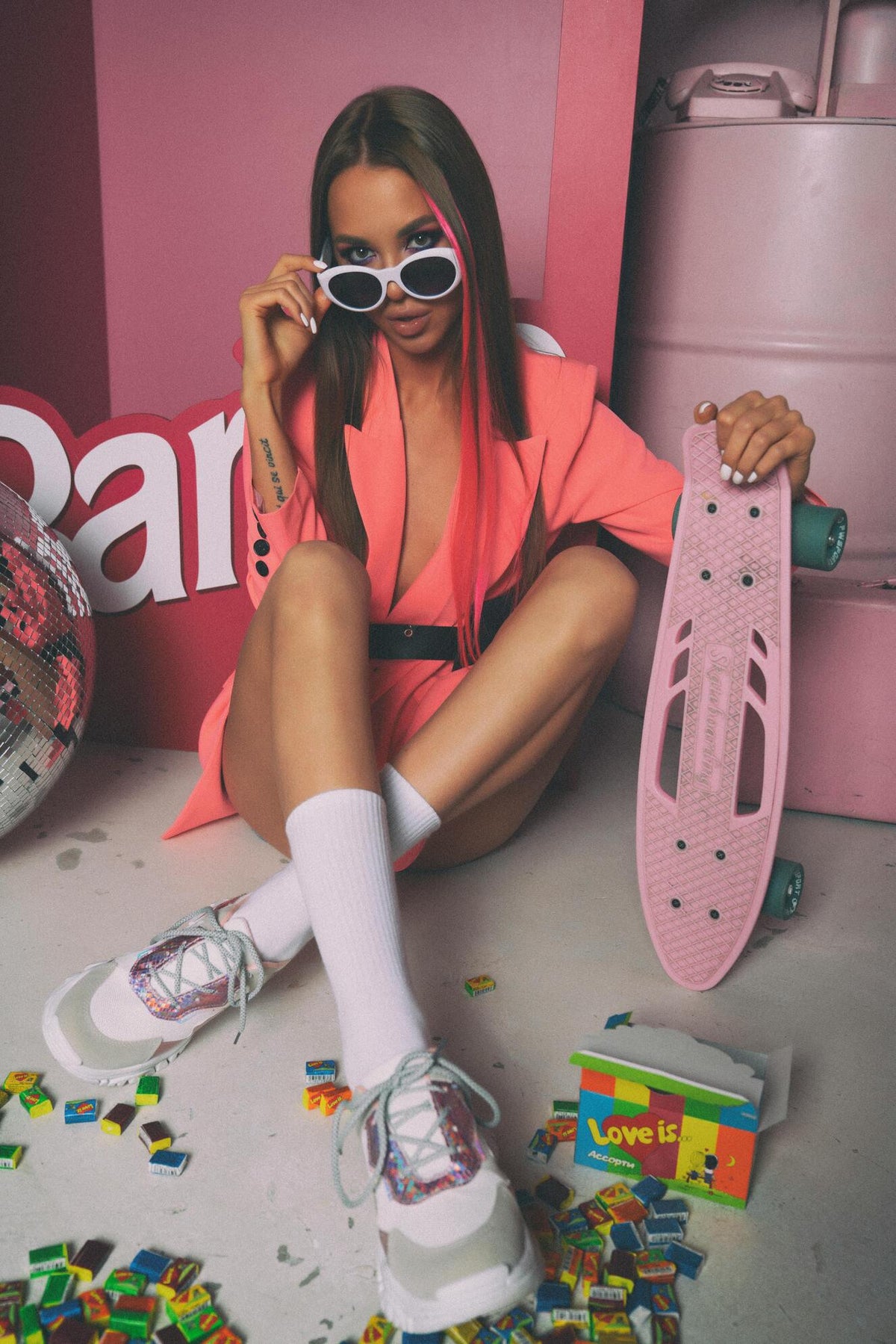 XAYWEAR pink jacket for women styled with white sneakers and a pink skateboard in urban setting