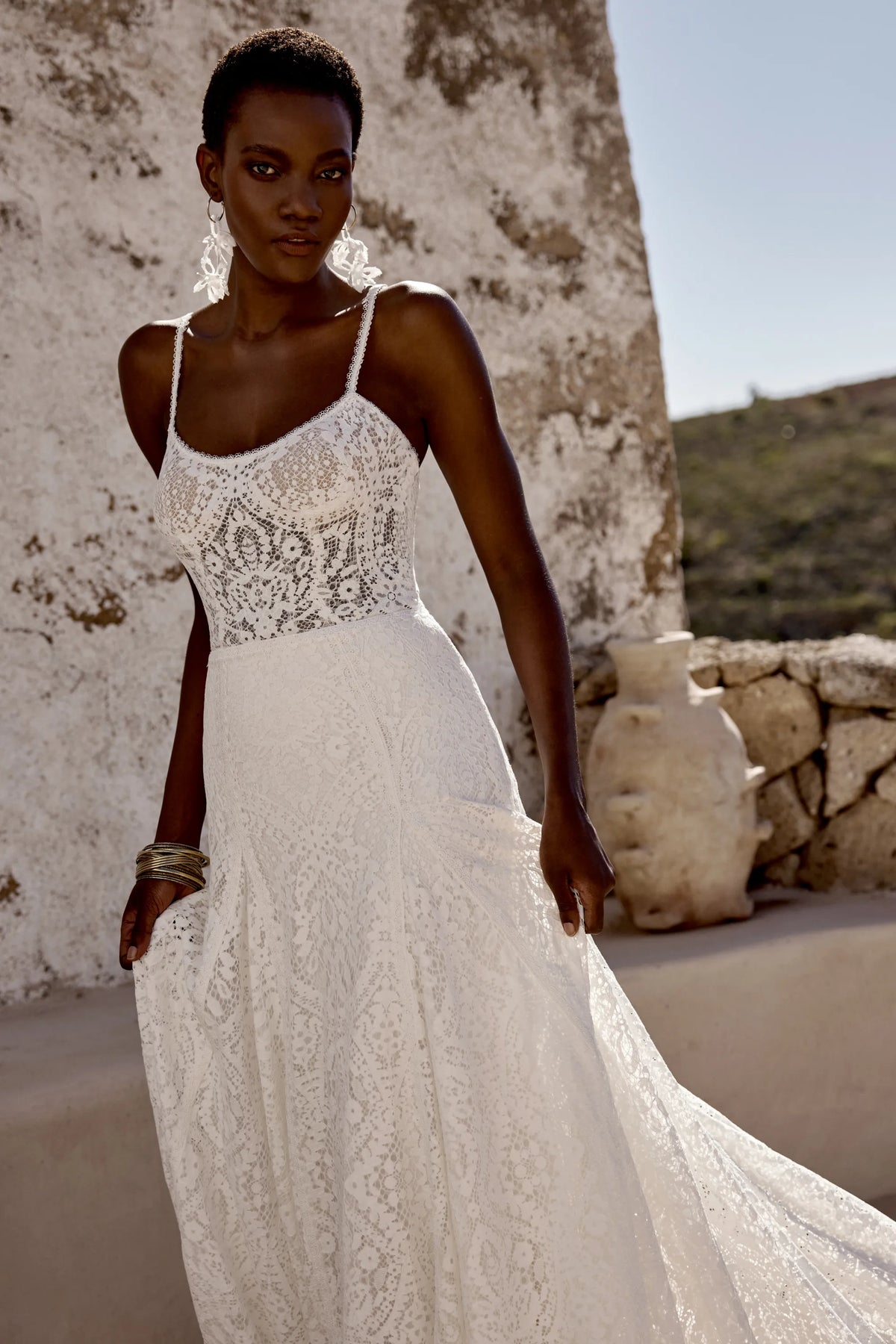 Elegant white wedding gown with intricate lace design and thin straps from XAYWEAR