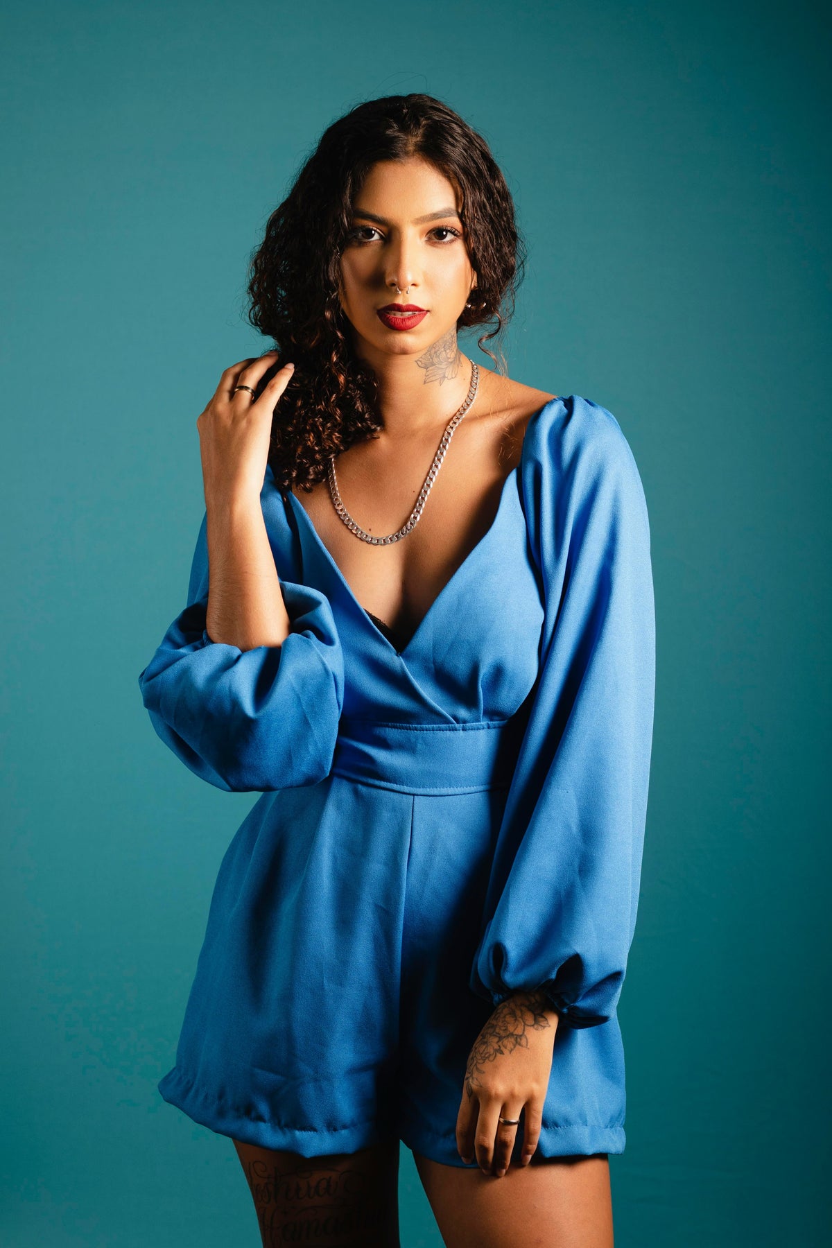 XAYWEAR women blue jumpsuit with long puff sleeves and deep V neckline styled on model