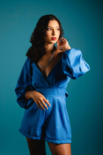 XAYWEAR women blue jumpsuit with long puff sleeves and deep V neckline on model