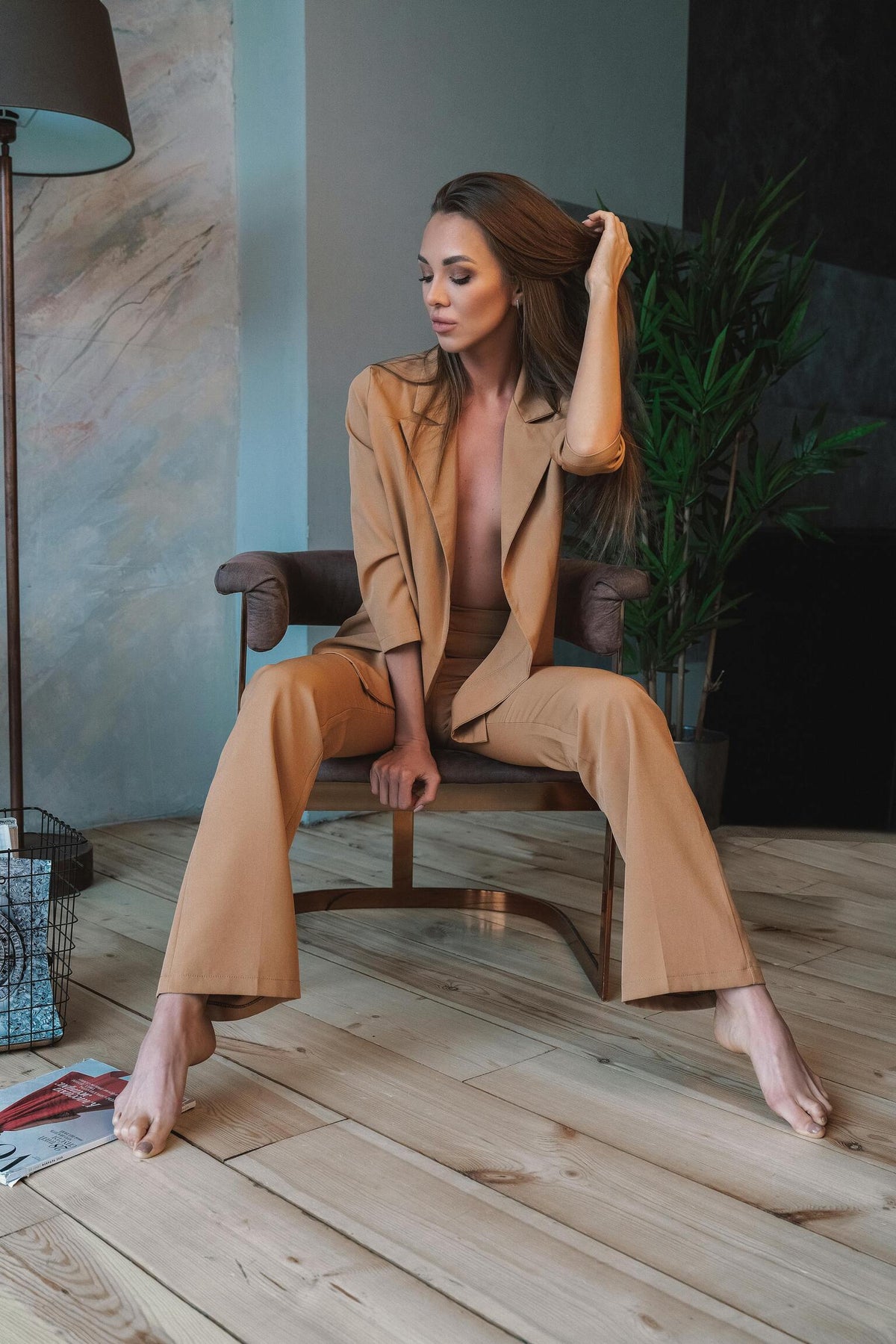 XAYWEAR women formal suit in tan color worn by model seated on chair in modern room