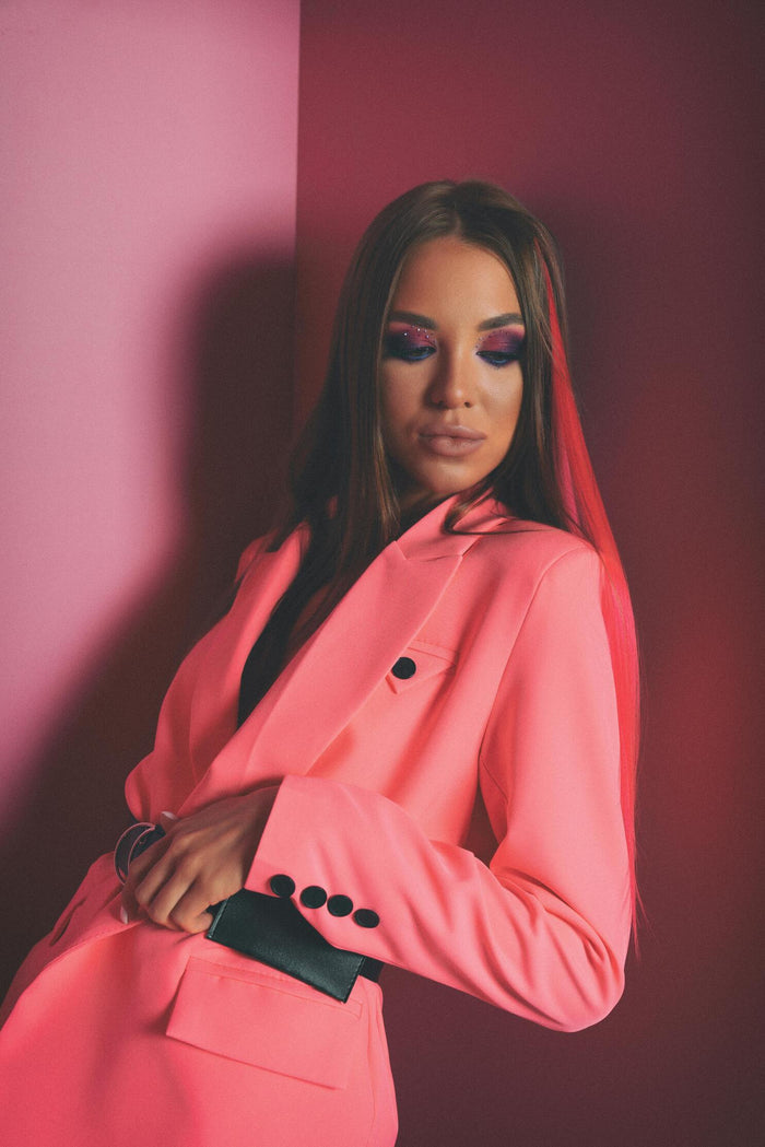 Stylish women pink blazer by XAYWEAR worn by model with bold makeup against two-tone pink background